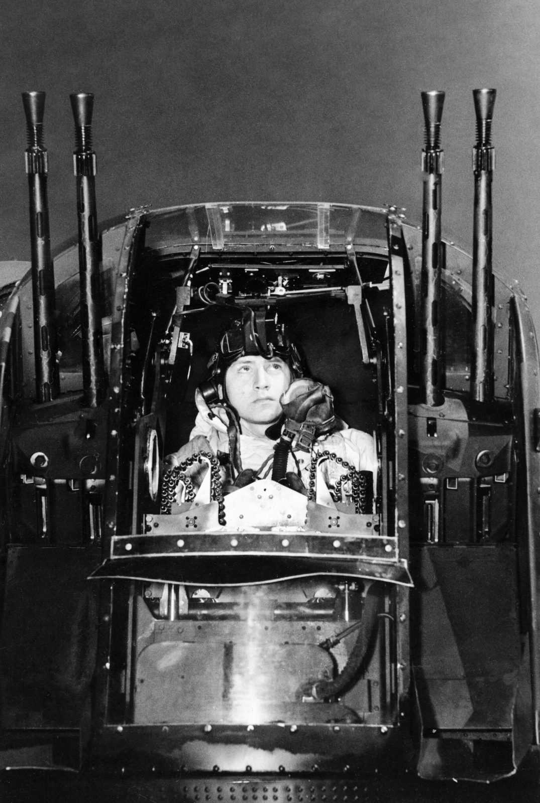 RAF rear gunner checking his guns in the tail turret of an Avro Lancaster before a night raid, No. 630 Squadron RAF, 1944