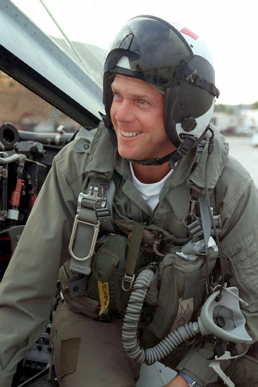 Payne Stewart in a US Navy flight suit and helmet, smiling, with an oxygen mask hanging at his chest, before a familiarisation flight in an F-14B Tomcat in October 1998