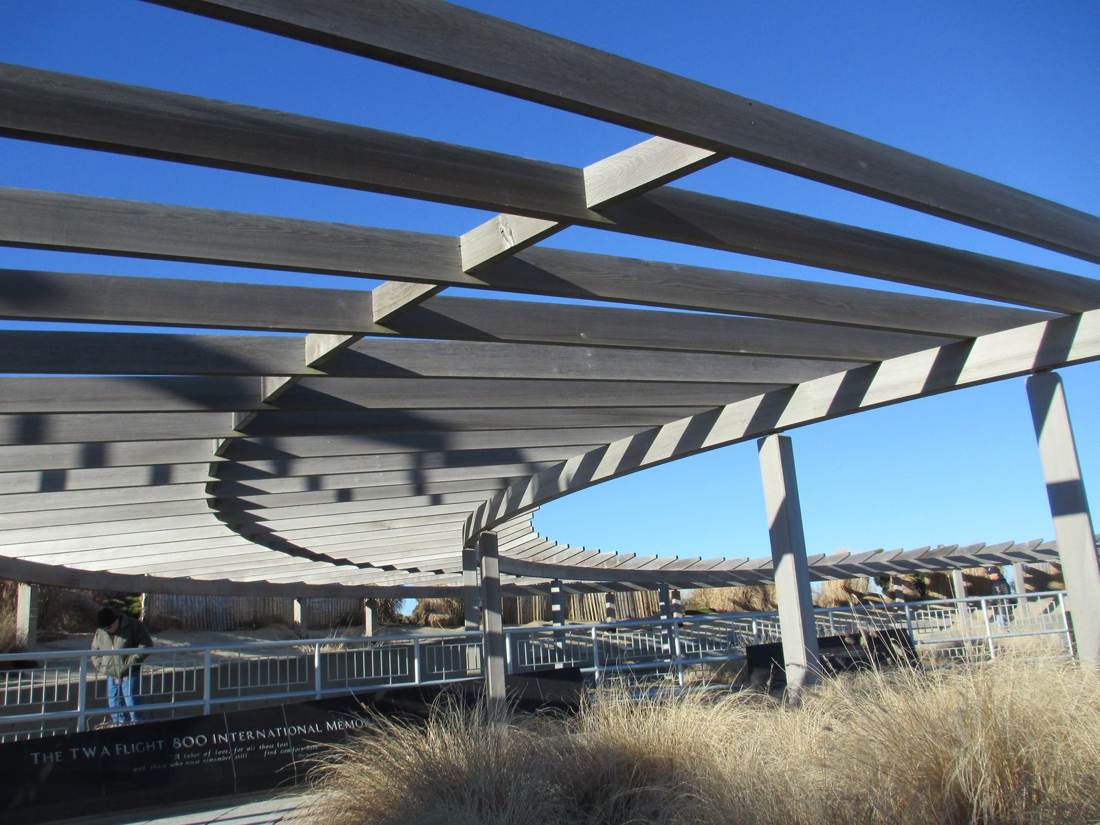 The TWA Flight 800 International Memorial at Smith Point County Park, Long Island: a curved wooden pergola over a black granite memorial wall